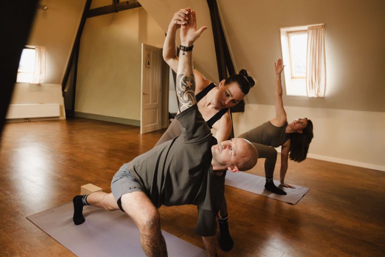 Twee deelnemers in een gedraaide yogahouding