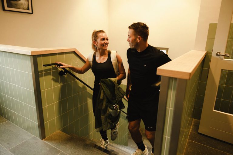 Twee leden lachend op de trap naar de studio